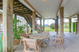 Un patio techado al aire libre con muebles de madera y piso de concreto.