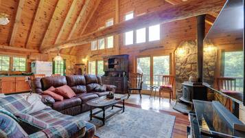 A spacious living room with a leather sofa, a coffee table, and a fireplace.
