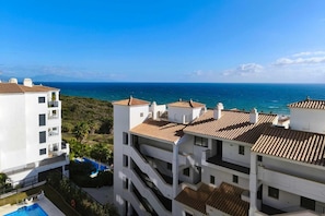 Zona residencial a la costa amb edificis blancs i teulades de teules, amb vistes al mar.