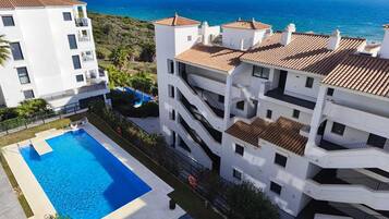Un edificio de varios pisos con piscina y vistas al mar.