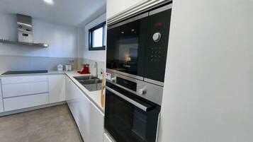 Una cocina moderna con electrodomésticos integrados, un ventanal y un refrigerador Bosch.