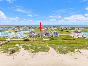 A coastal residential area with houses, a beach, and a clear sky. - Beachfront Access | 4BR | Hot Tub | Ocean Views (Galveston)