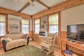 A cozy room with a sofa, a rocking chair, a television, and a pet carrier. - Charming Family-friendly Getaway in Sandwich! (Sandwich)