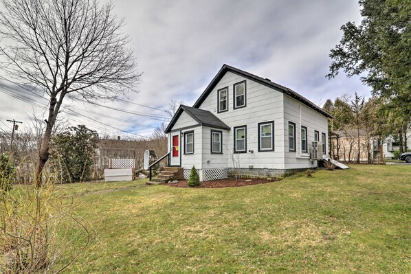 A two-story house with a front porch, a small front yard, and a driveway.