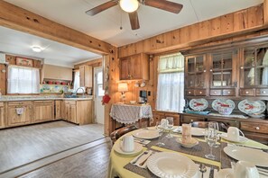 A wooden interior with a dining area set for a meal, featuring a table with plates, glasses, and cutlery.