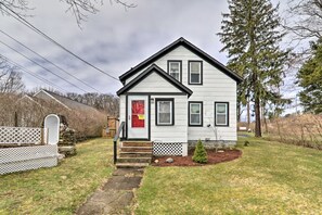 A two-story house with a front porch, a red door, and a small front yard. - Charming Family-friendly Getaway in Sandwich! (Sandwich)