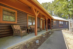 A log cabin with a porch, wicker furniture, and a welcome sign. - 2 Mi to Historic Dtwn! Family Getaway w/ Game Room (Granbury)
