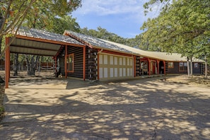 A log cabin with a covered porch, a garage, and a fenced-in area. - 2 Mi to Historic Dtwn! Family Getaway w/ Game Room (Granbury)