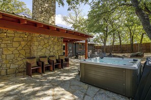 A stone building with a wooden pergola, outdoor seating, and a hot tub. - 2 Mi to Historic Dtwn! Family Getaway w/ Game Room (Granbury)