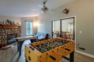 Una habitación con mesa de futbolín, chimenea y ventana.