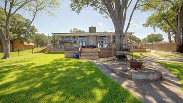 A two-story house with a front porch, a covered patio, and a well-maintained lawn.