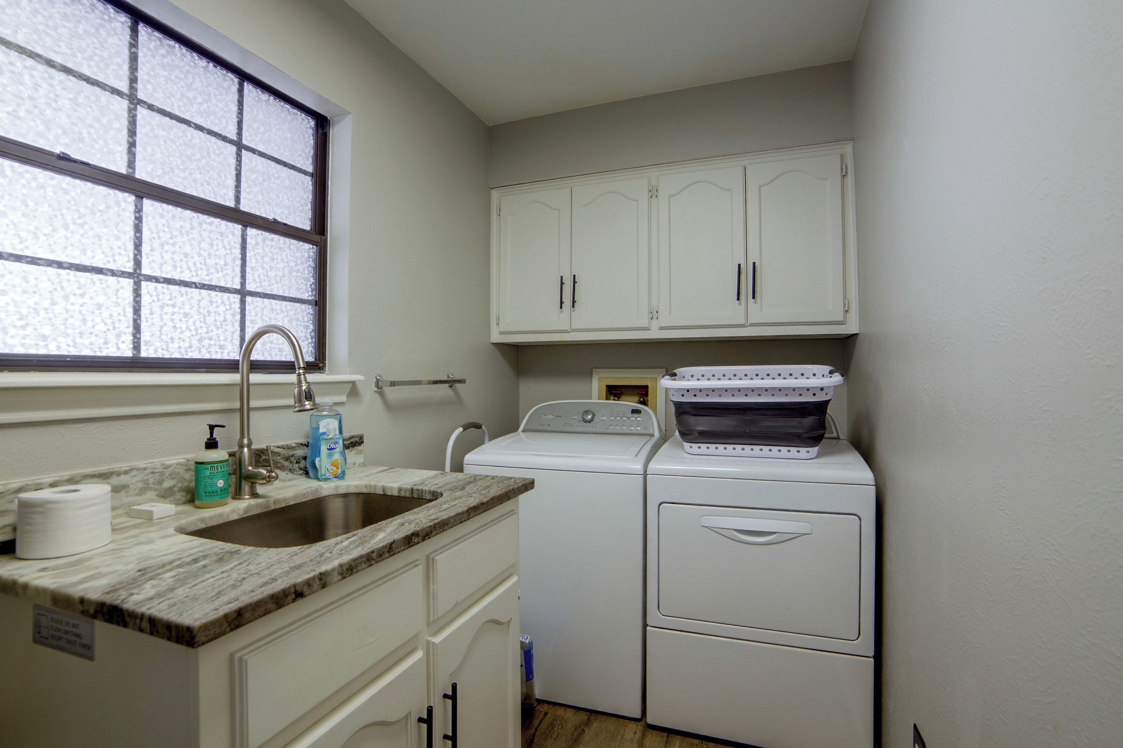 A compact kitchen with a sink, countertop, and a washing machine.