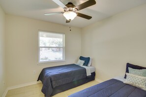 A bedroom with two beds, a ceiling fan, and a window with blinds. - < 2 Mi to Beach! Home w/ Fenced Yard in Gulfport (Gulfport)