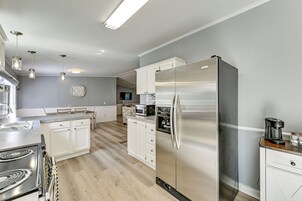 Una cocina moderna con electrodomésticos de acero inoxidable, un comedor con mesa de madera y vista al salón.