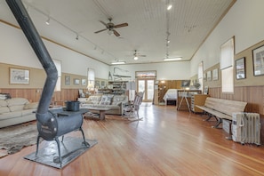 A spacious living room with a large fireplace, wooden flooring, and a cozy seating area.