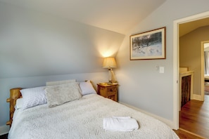 A bedroom with a bed, a nightstand, a lamp, and a painting on the wall. - Quiet Countryside Escape w/ Views in Talking Rock (Talking Rock)