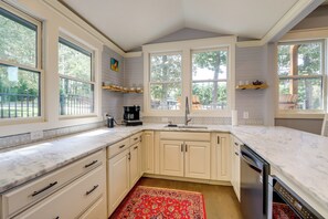 A kitchen with white cabinets, a marble countertop, and a red patterned rug. - Quiet Countryside Escape w/ Views in Talking Rock (Talking Rock)