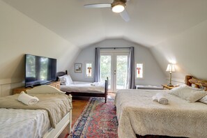 Ein Schlafzimmer mit zwei Betten, einem Fernseher und einem Deckenventilator.
