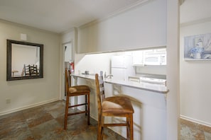 A kitchen with a white countertop, two wooden bar stools, a white refrigerator, and a stove. - Resort Perks! Lakefront Unit Extended Stays (Hot Springs)
