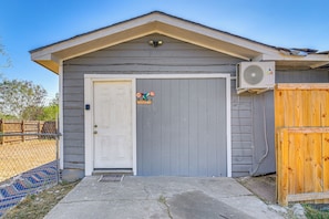 A small building with a white door, a welcome sign, and an air conditioning unit. - Gateway to Downtown Harlingen! Quaint Unit (Harlingen)
