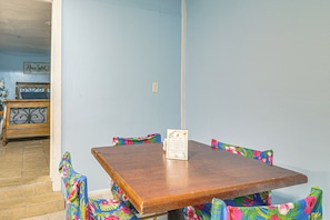 A dining area with a wooden table and colorful floral-patterned chairs. - Gateway to Downtown Harlingen! Quaint Unit (Harlingen)