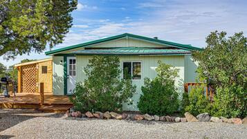 A small, single-story building with a green roof and a front porch.