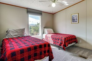 A room with two beds, a window with a view, a ceiling fan, and a framed picture on the wall. - Colorado Getaway at the Base of Sangre de Christos (Fort Garland)