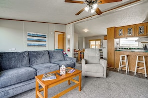 A living room with a grey sofa, a wooden coffee table, and a ceiling fan. - Colorado Getaway at the Base of Sangre de Christos (Fort Garland)