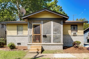 A single-story house with a front porch, a satellite dish, and a small garden area.