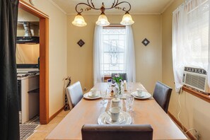 A dining area with a wooden table set for four, surrounded by chairs. - Near Dtwn Jackson: Home w/ Screened Porch (Jackson)