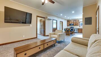 A spacious living room with a large sectional sofa, a wooden bench, and a ceiling fan.