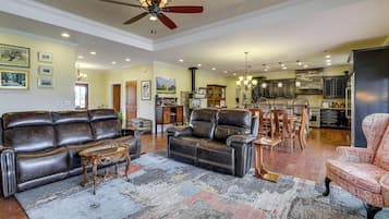 A spacious living room with a leather sofa, a coffee table, and a patterned rug.