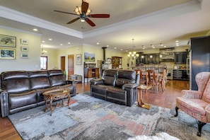 A spacious living room with a leather sofa, a coffee table, and a patterned rug. - Mtn-view Ranch Near Black Canyon Nat'l Park (Crawford)