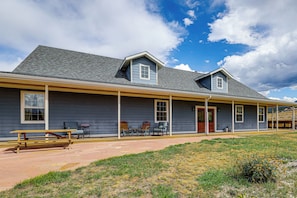 A two-story building with a covered porch and a patio area.