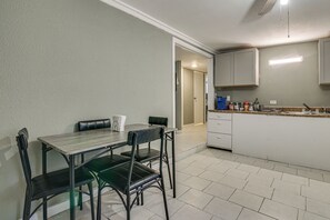 A compact kitchen with a dining area, featuring a table with chairs, a countertop with kitchen appliances, and cabinets. - Central Rio Grande Valley Hub w/ Full Kitchen! (La Feria)
