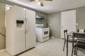 A kitchen with a white refrigerator, stove, and oven, a ceiling fan, and a dining table with chairs. - Central Rio Grande Valley Hub w/ Full Kitchen! (La Feria)