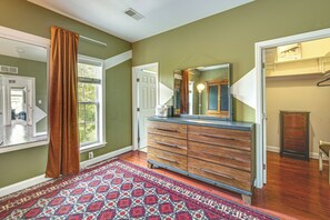 A hallway with a patterned rug, wooden dresser, and a mirror. - Walden at Mechanicsburg - Walking Trails (Mechanicsburg)