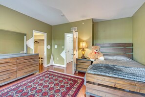A bedroom with a bed, a dresser, a lamp, a teddy bear, and a patterned rug. - Walden at Mechanicsburg - Walking Trails (Mechanicsburg)