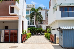 A gated residential area with modern architecture, including a flat-roofed building and a multi-story structure with a balcony. - Kingsley by Redolive4bhknr Apolloecrnr Sipcot (Chennai)