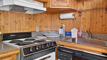 A kitchen with a stove, dishwasher, and wooden cabinets.