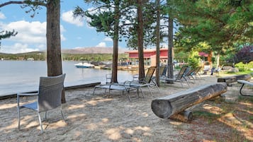A lakeside resort with lounge chairs and a dock with boats.