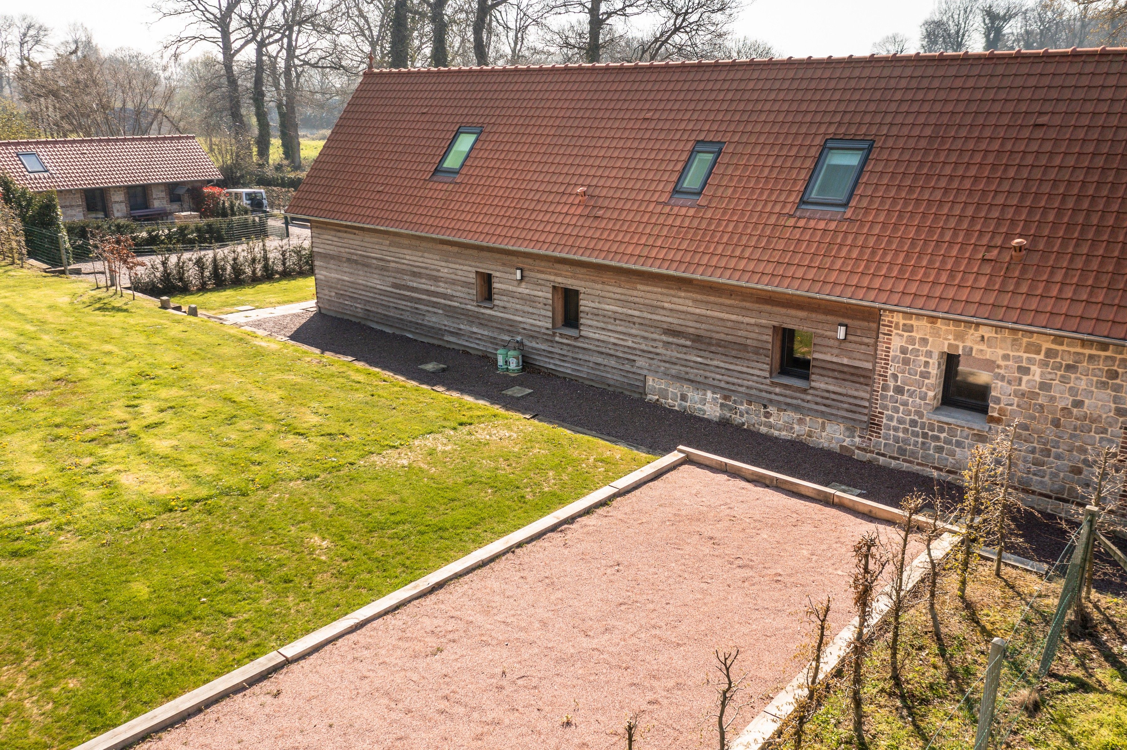 Ein zweistöckiges Steinhaus mit roten Ziegeln und einem gepflasterten Auffahrt.