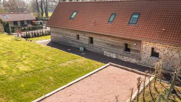 Ein zweistöckiges Steinhaus mit roten Ziegeln und einem gepflasterten Auffahrt.