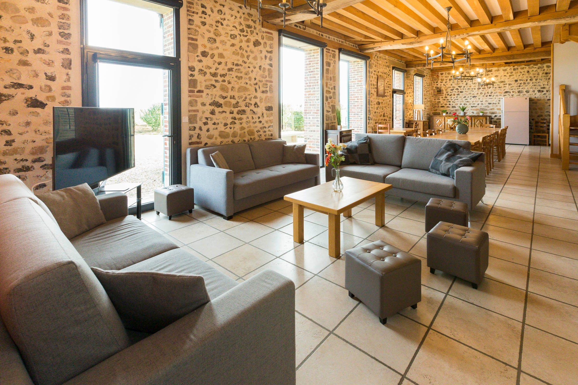A spacious living area with sofas, a coffee table, and a TV.