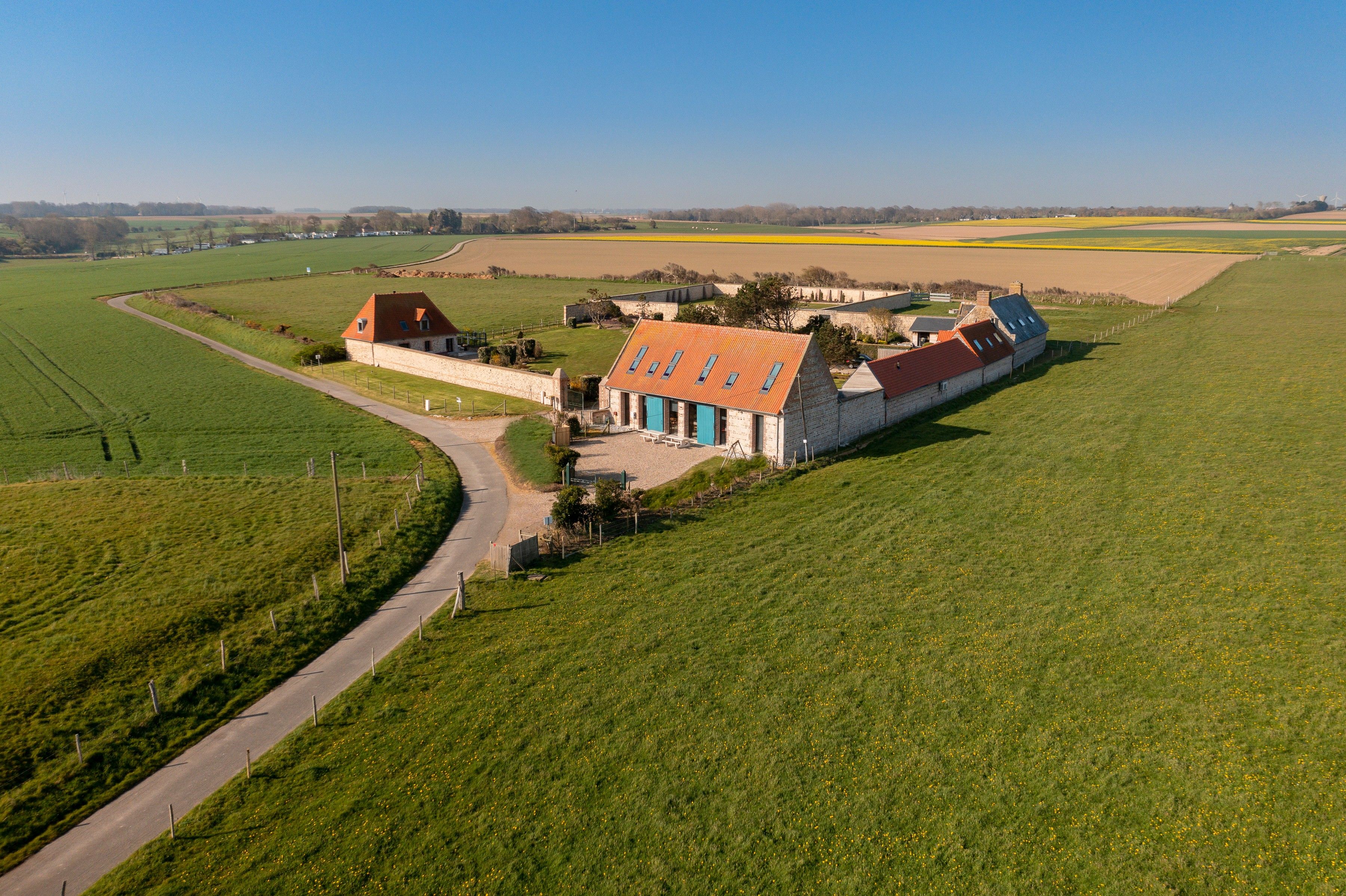 Il s’agit d’une propriété rurale comprenant un bâtiment principal doté d’un toit rouge et une dépendance plus petite attenante.
