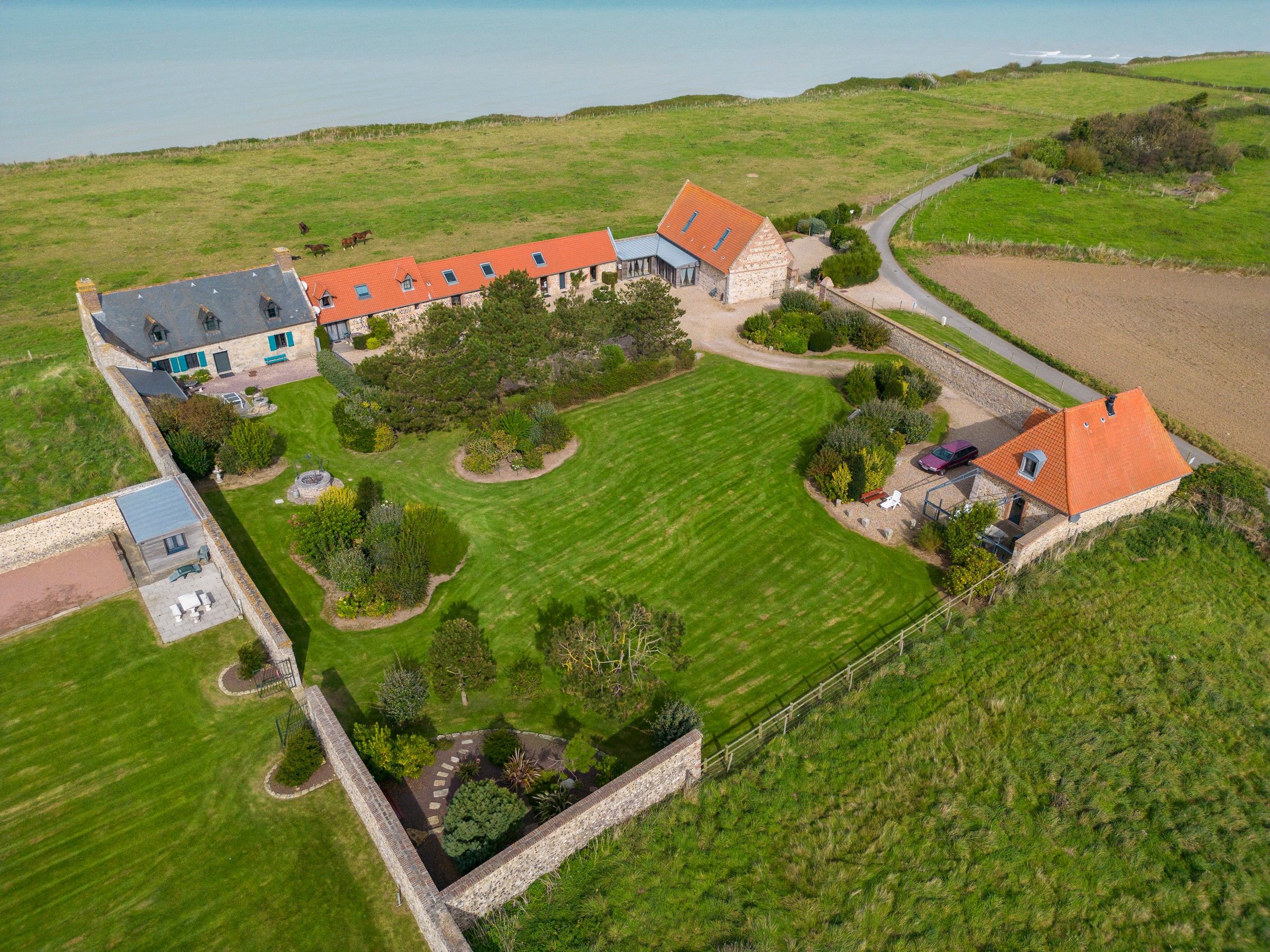 A large estate with multiple buildings, a well-maintained lawn, and a fenced property.