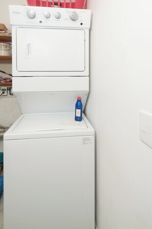 A white Whirlpool washer with a blue detergent bottle on the door. - Quiet 3BR townhouse in gated Playacar (Playa del Carmen)