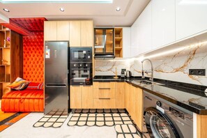 Une cuisine moderne dotée d’appareils électroménagers intégrés, de meubles en bois et d’un dosseret en marbre.