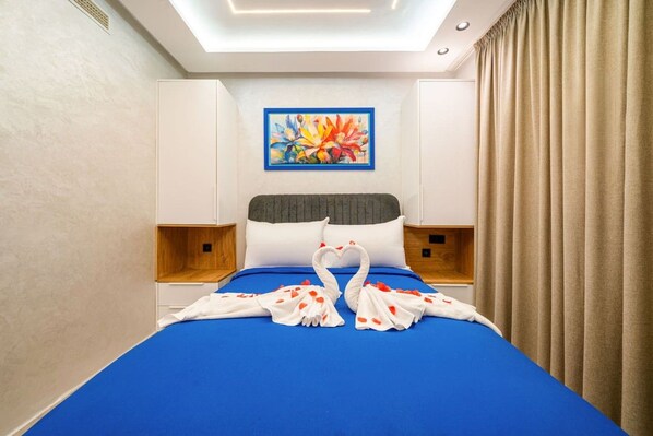 Une chambre d’hôtel avec un lit, un tableau au mur et une fenêtre avec des rideaux.
