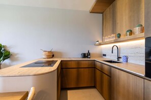 Eine moderne Küche mit Holzschränken, einer integrierten Spüle und einer Arbeitsplatte.